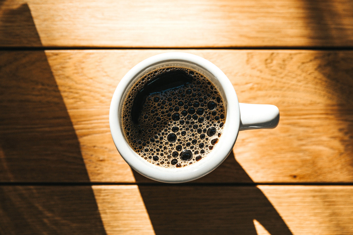 a cup of freshly brewed dancing ox coffee sitting on a table in the sunshine