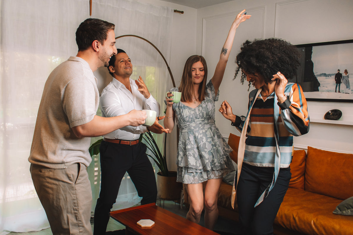 Group of people dancing and socializing in a living room with Dancing Ox Coffee.