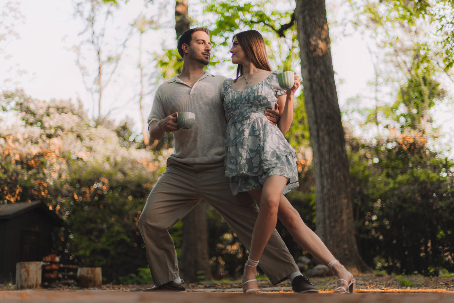 Couple dancing outdoors in a park with trees and greenery in the background. Drinking Dancing Ox Coffee
